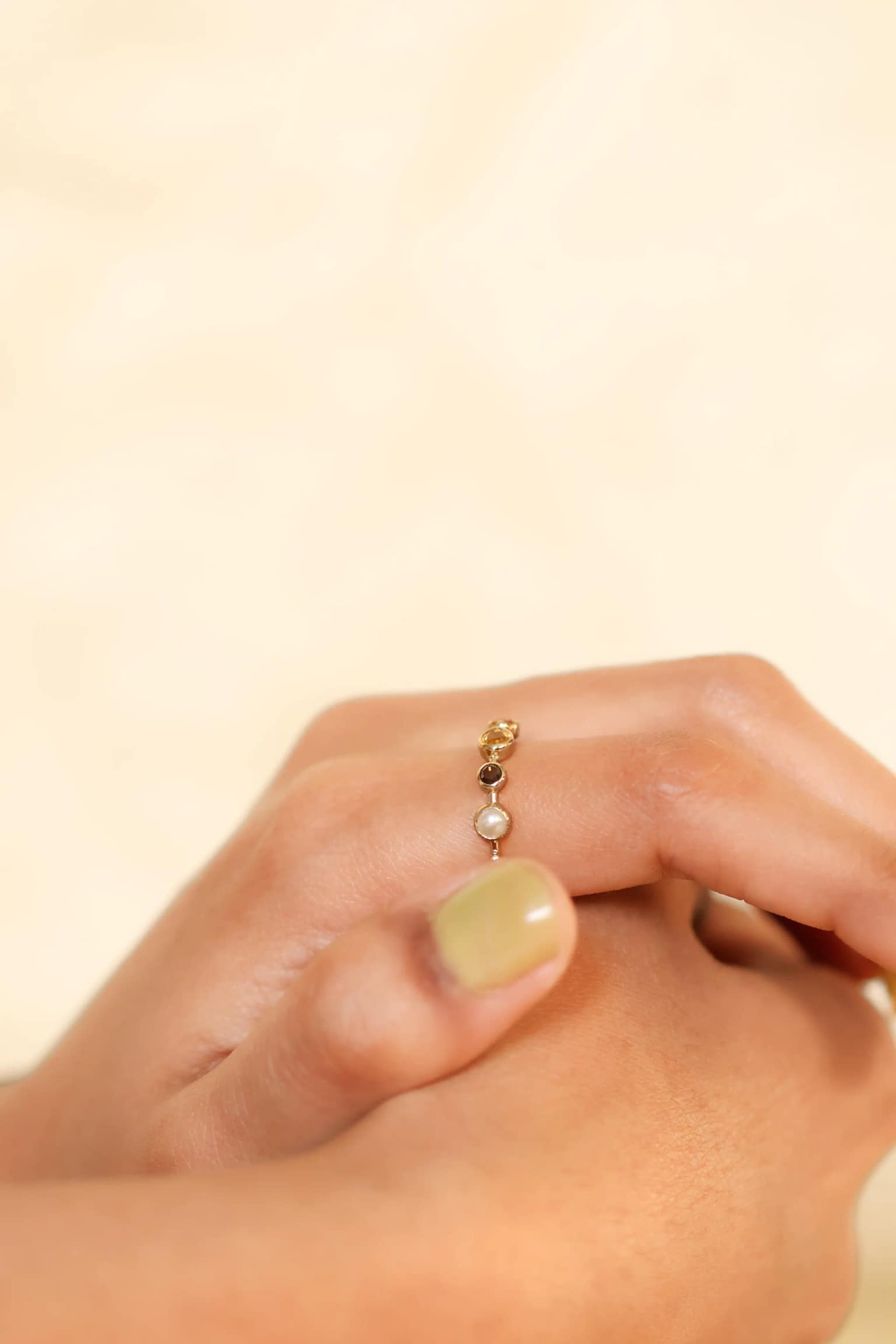 Pink butterfly ring held in gloved hands